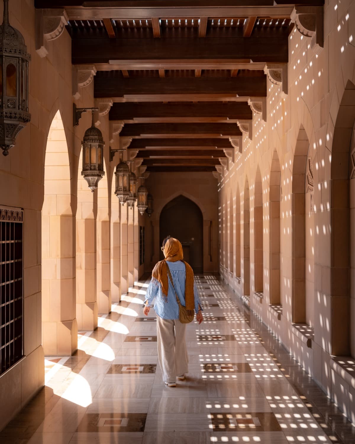 Alice walking through an arched corridor in Oman